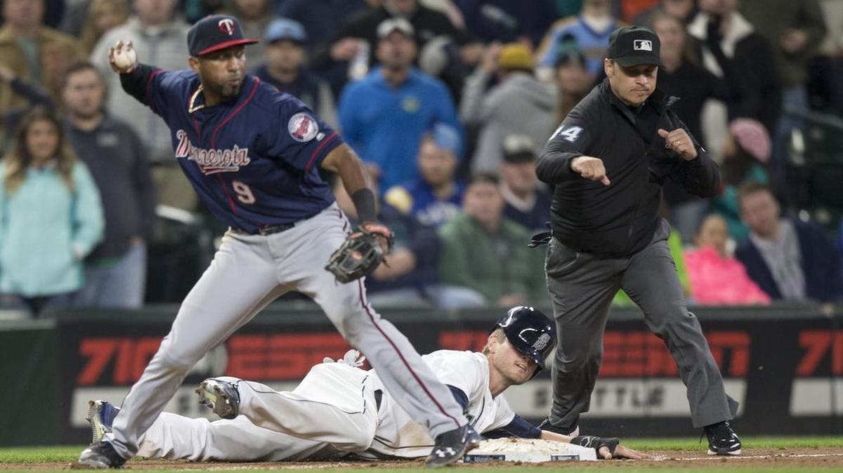 Seattle Mariners’ Shawn O’Malley lays on the ground after being tagged out on an attempted steal by Minnesota Twins third baseman Eduardo Nunez, who threw to second to complete a double play in the ninth inning on Saturday.