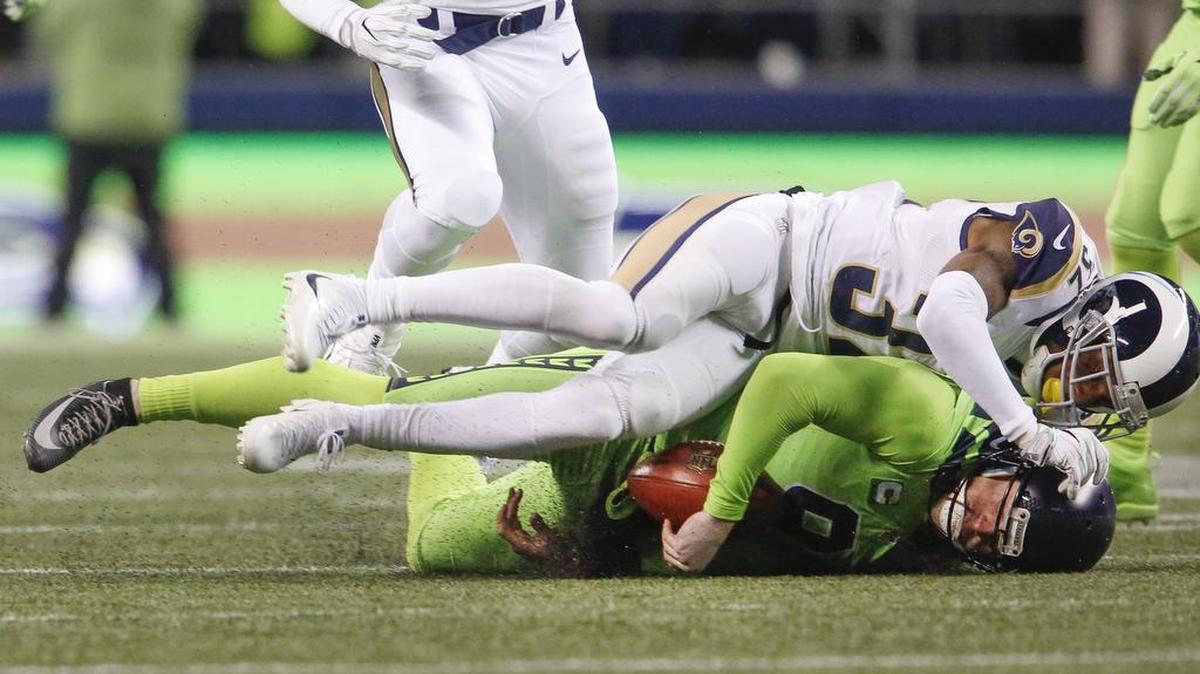 Seahawks punter Jon Ryan, bottom, is tackled by Rams player Jeron Johnson during a fake punt in the fourth quarter. Ryan ran for 26 yards before fumbling the ball, which he recovered.