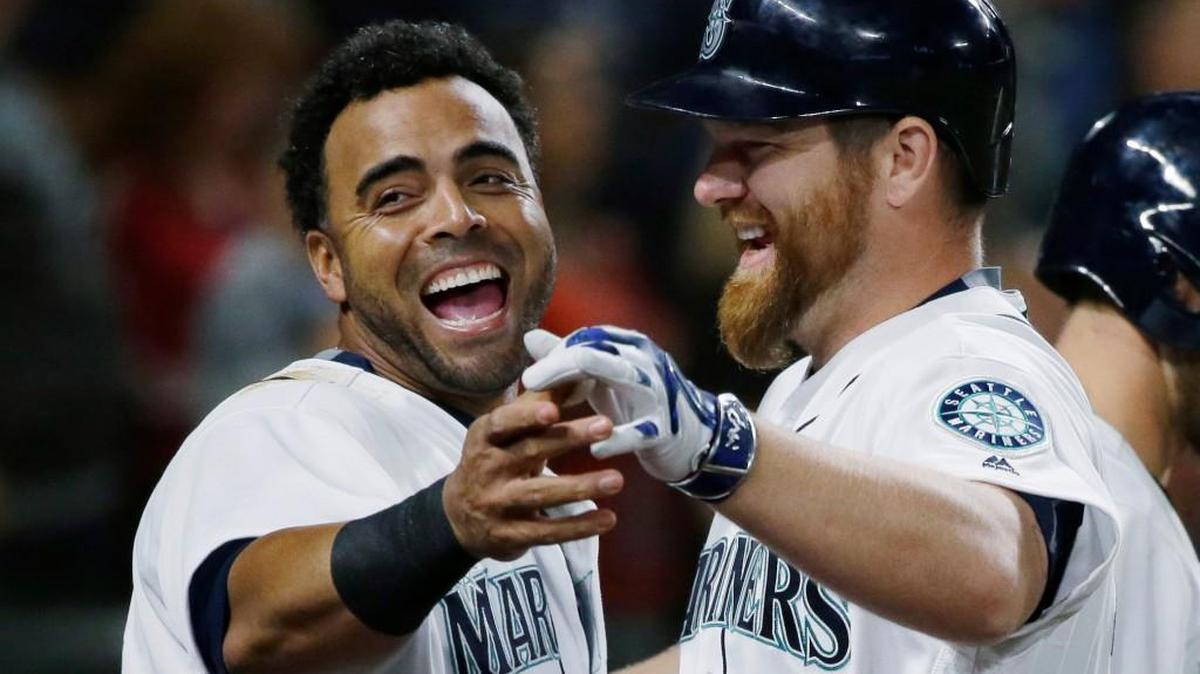 Seattle’s Nelson Cruz, left, reacts as he greets Adam Lind, right, after Lind hit a solo home run against Baltimore on Saturday. The Mariners have seven players with 10 or more home runs and the team’s 123 homers are second in Major League Baseball.