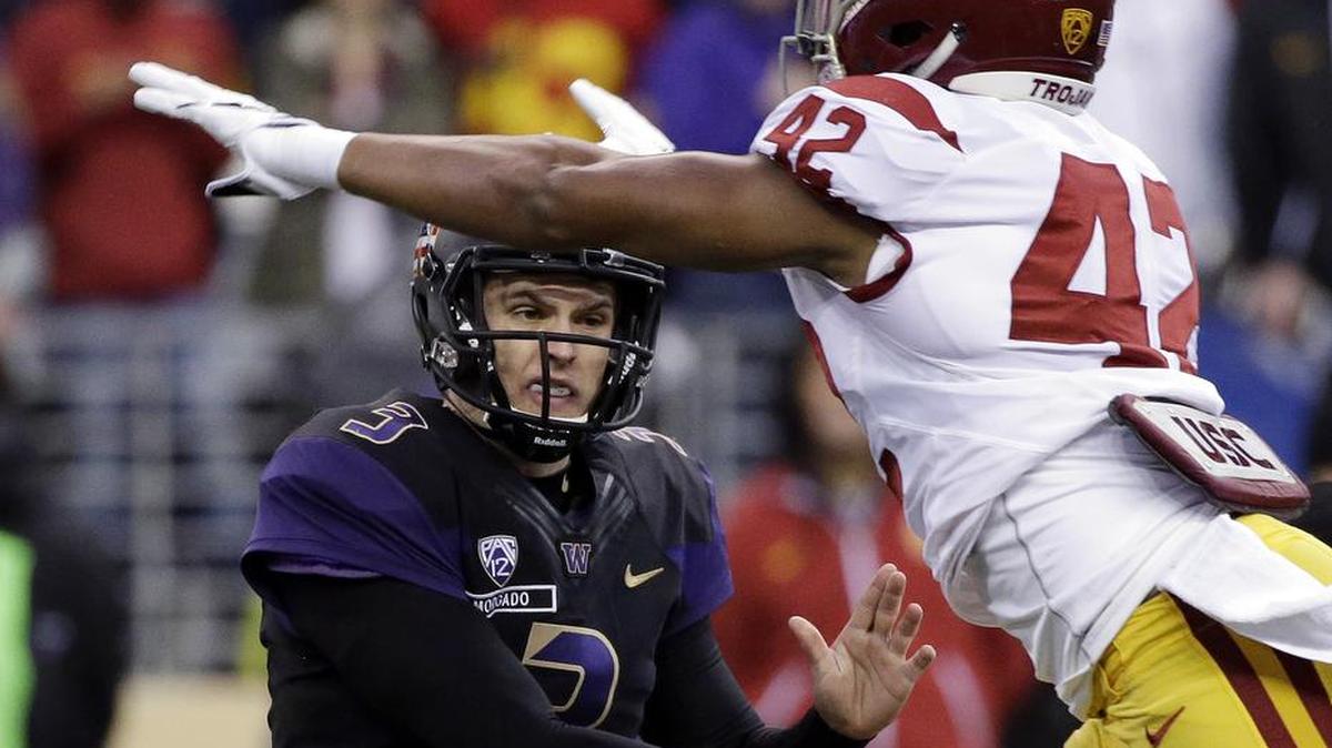 Washington quarterback Jake Browning, left, gets a pass off under pressure from USC’s Uchenna Nwosu during the first half Saturday in Seattle.