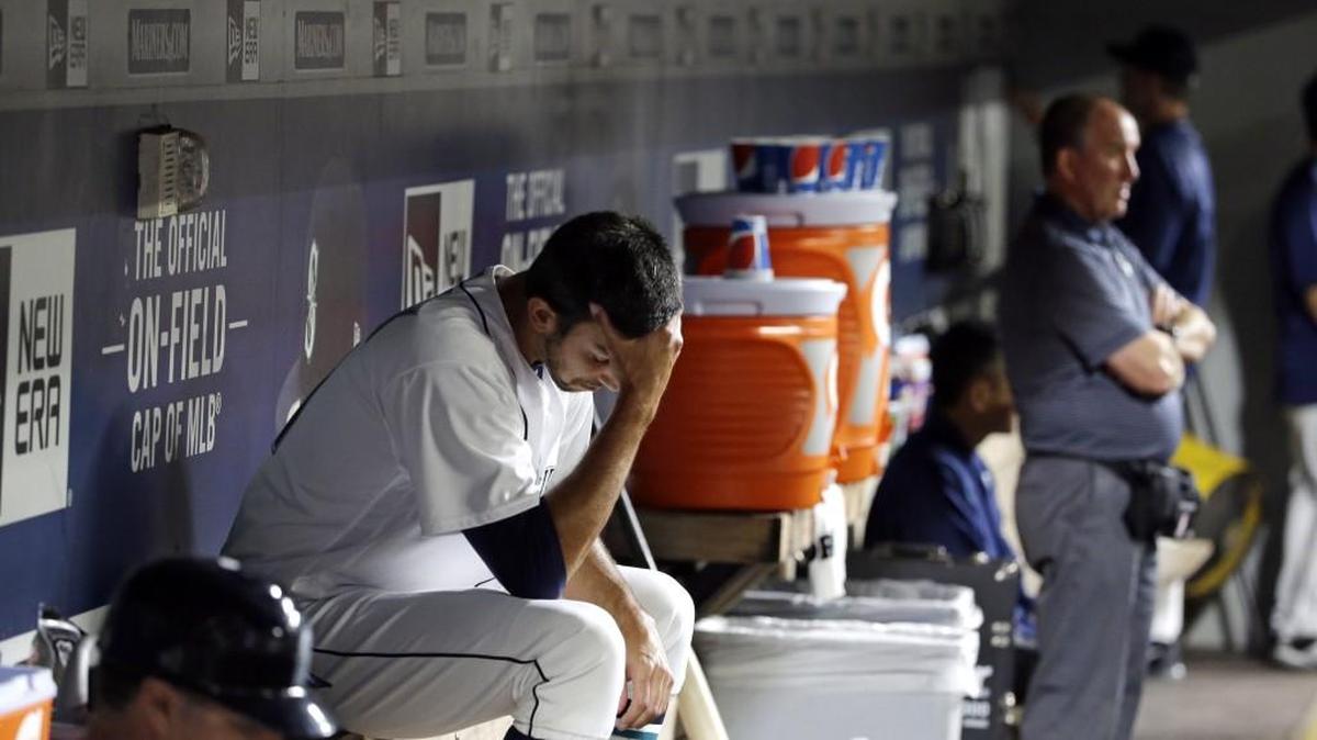 Seattle relief pitcher Steve Cishek looks down as he sits in the dugout after giving up a home run and being relieved in the ninth inning against Boston. The Mariners lost the game 2-1 to the Red Sox.