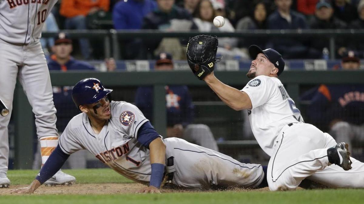 Seattle Mariners relief pitcher Dan Altavilla watches the ball pop loose from his glove as Houston Astros' Carlos Correa scores on a wild pitch in the seventh inning of a baseball game Wednesday, April 12, 2017, in Seattle.