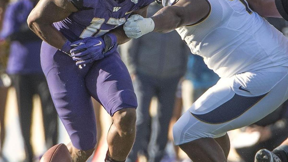 
Huskies tailback Dwayne Washington fumbles the ball Saturday with his team marching toward a potential go-ahead touchdown. UW lost the game 30-24, committing five turnovers.
