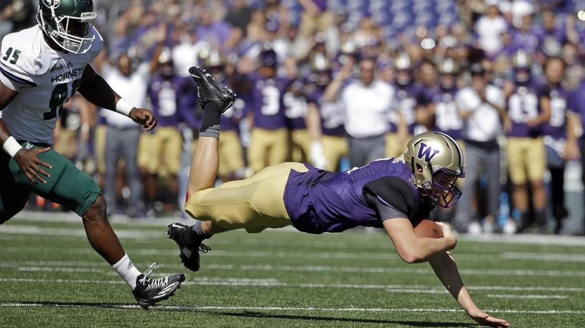 
Washington quarterback Jake Browning stumbles forward for a first-down run Saturday. Columnist John McGrath speculates that Browning has the potential to own several prestigious Huskies passing records before his career is over. 
