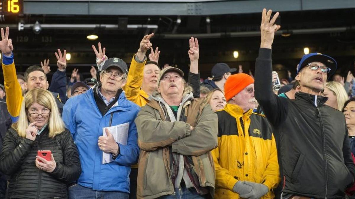 Fans sing “one, two, three strikes your out" during the seventh-inning stretch at the Mariners’ home opener Monday.
