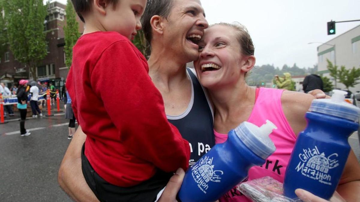 Jesse and Jenny Stevick hold three-year-old son Wesley after winning the Capital City Marathon men’s and women’s divisions in 2012.